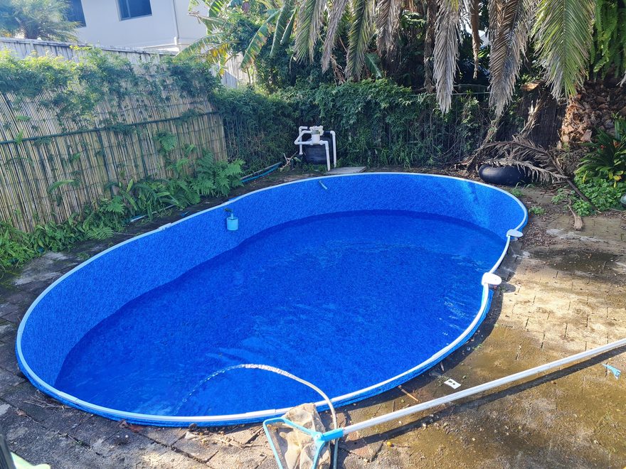 A pool with clear blue water after a clean, among palms